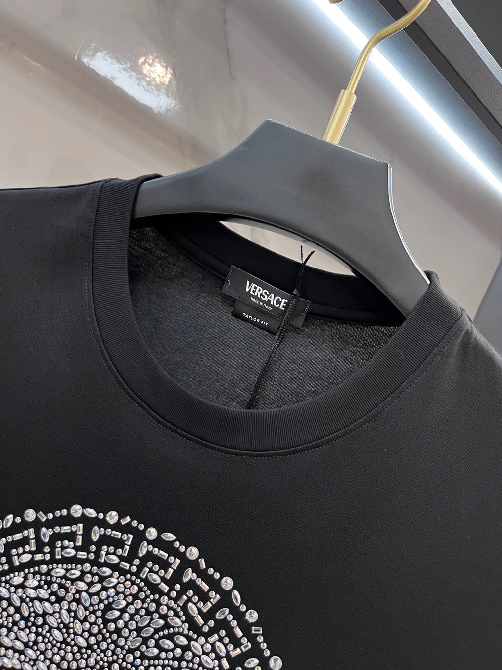 Black Versace T-shirt neckline with small brand tag inside collar
