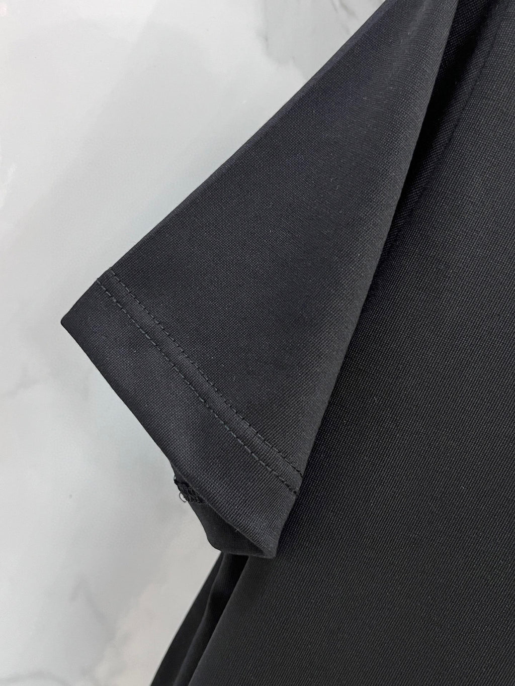 Black T-shirt sleeve and side seam hem detail