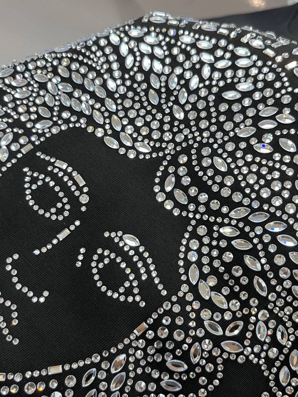 Black T-shirt with large rhinestone Medusa-style design across the chest