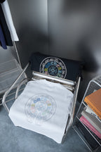 Set of two graphic T-shirts: white and black folded on metal stand
