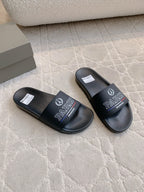 Black Balenciaga slide sandals with Paris logo straps, shown from the side
