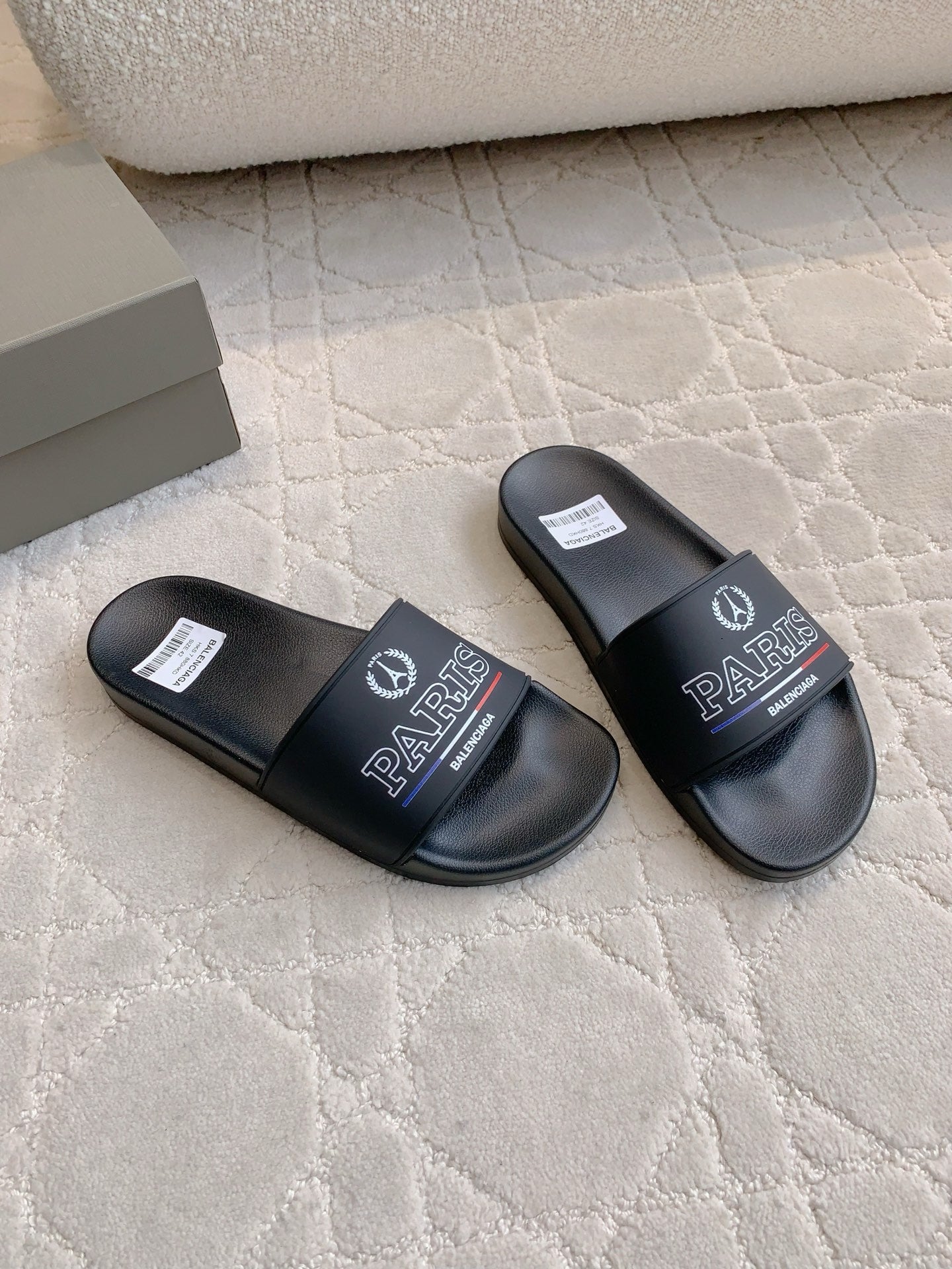Black Balenciaga slide sandals with Paris logo straps, shown from the side