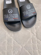 Black Balenciaga slide sandals with PARIS and BALENCIAGA text on front straps