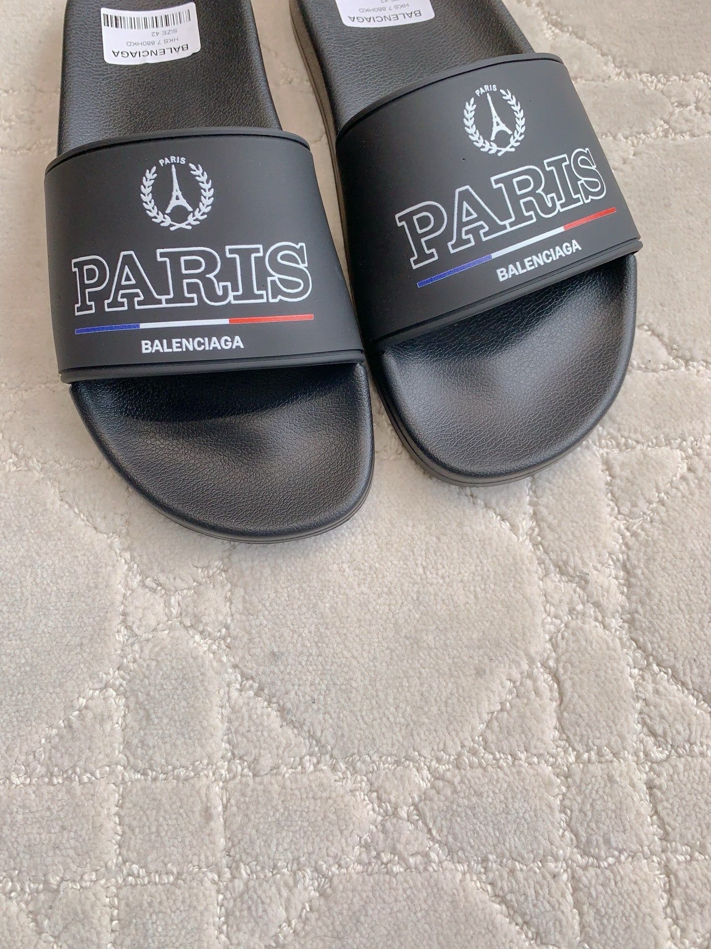 Black Balenciaga slide sandals with PARIS and BALENCIAGA text on front straps