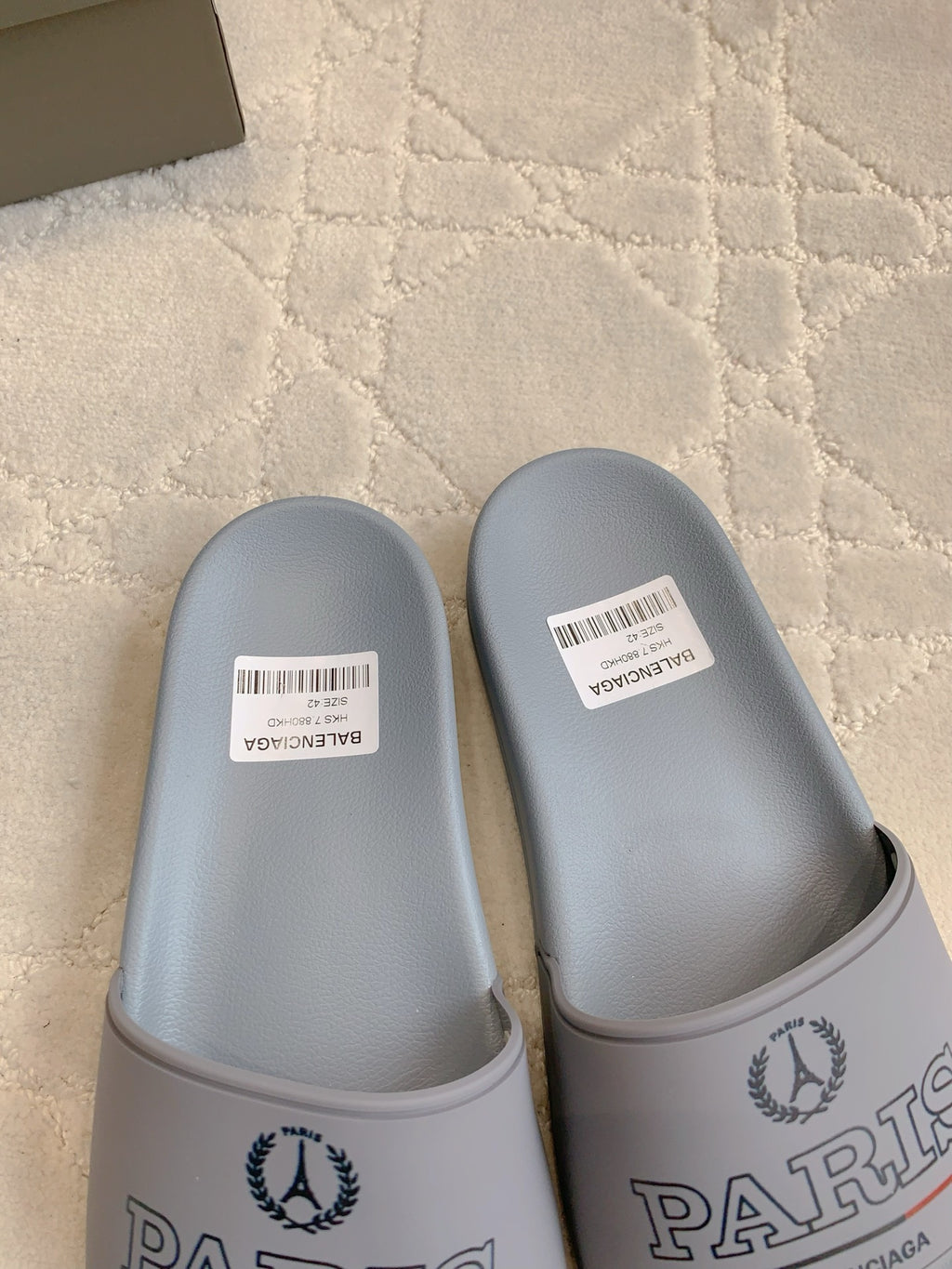Balenciaga light blue slide sandals, close-up of front straps and barcode labels