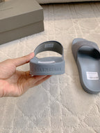 Balenciaga light blue slide sandals, hand holding one with heel branding