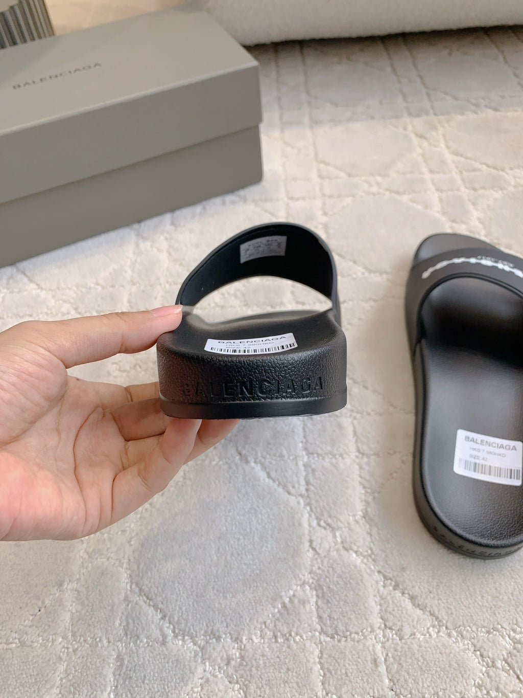 Black slide sandal heel with embossed logo text on the back strap