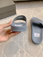 Light blue slide sandals with heel print and barcode labels