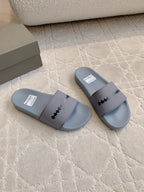 Pair of light blue slide sandals with central strap logo