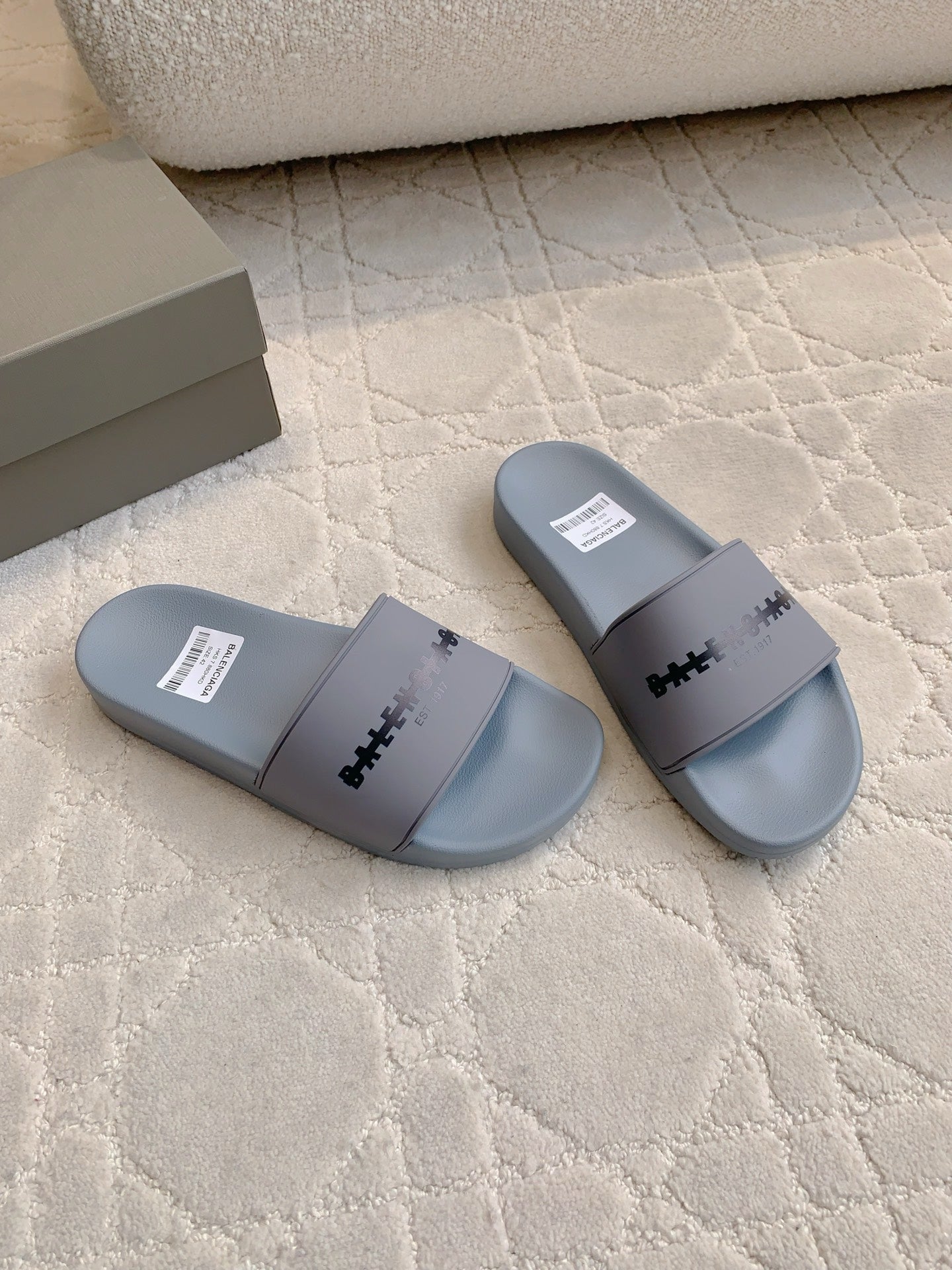 Pair of light blue slide sandals with central strap logo
