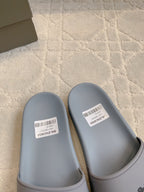 Light blue slide sandals with white size labels on footbeds