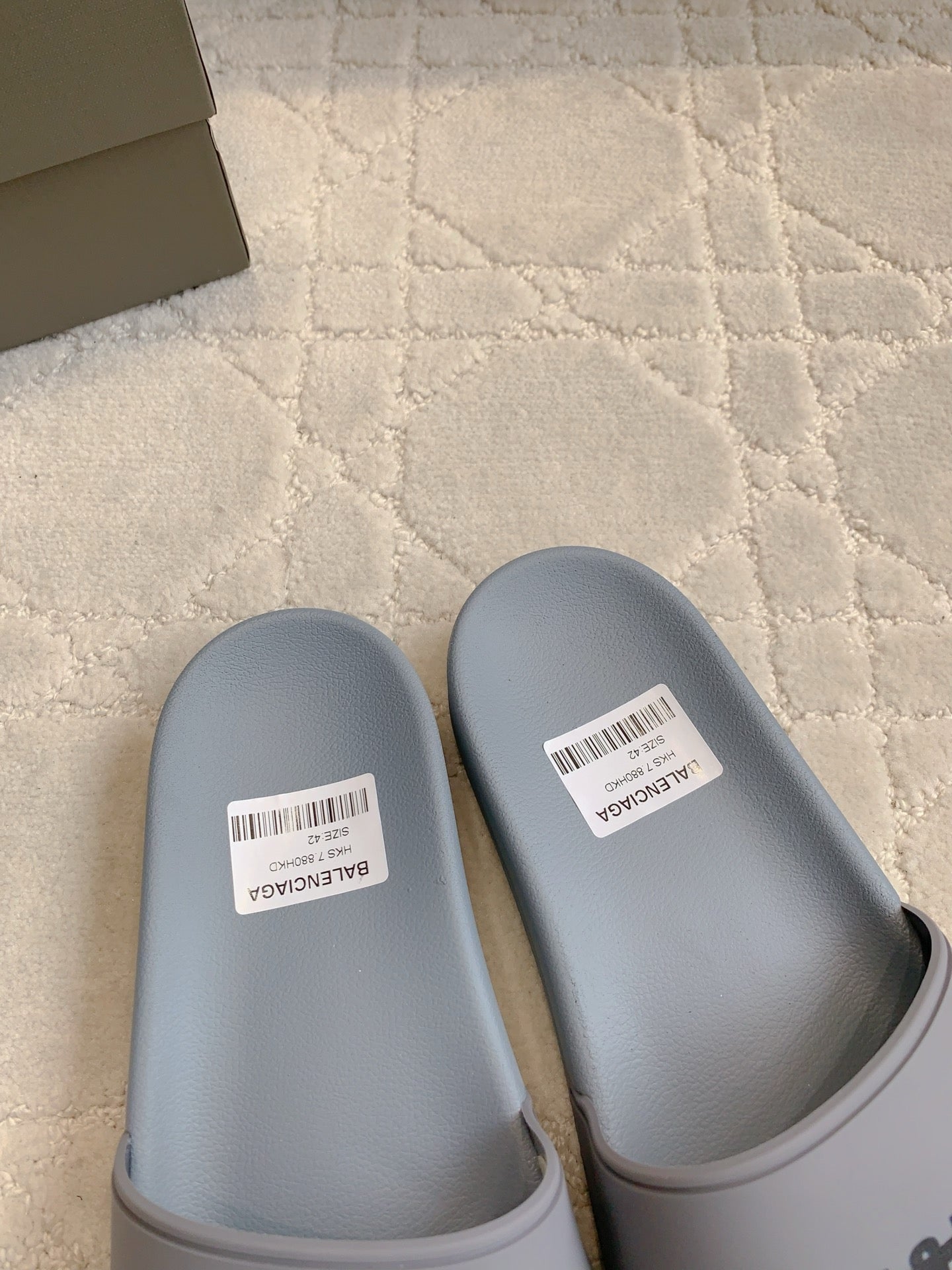 Light blue slide sandals with white size labels on footbeds