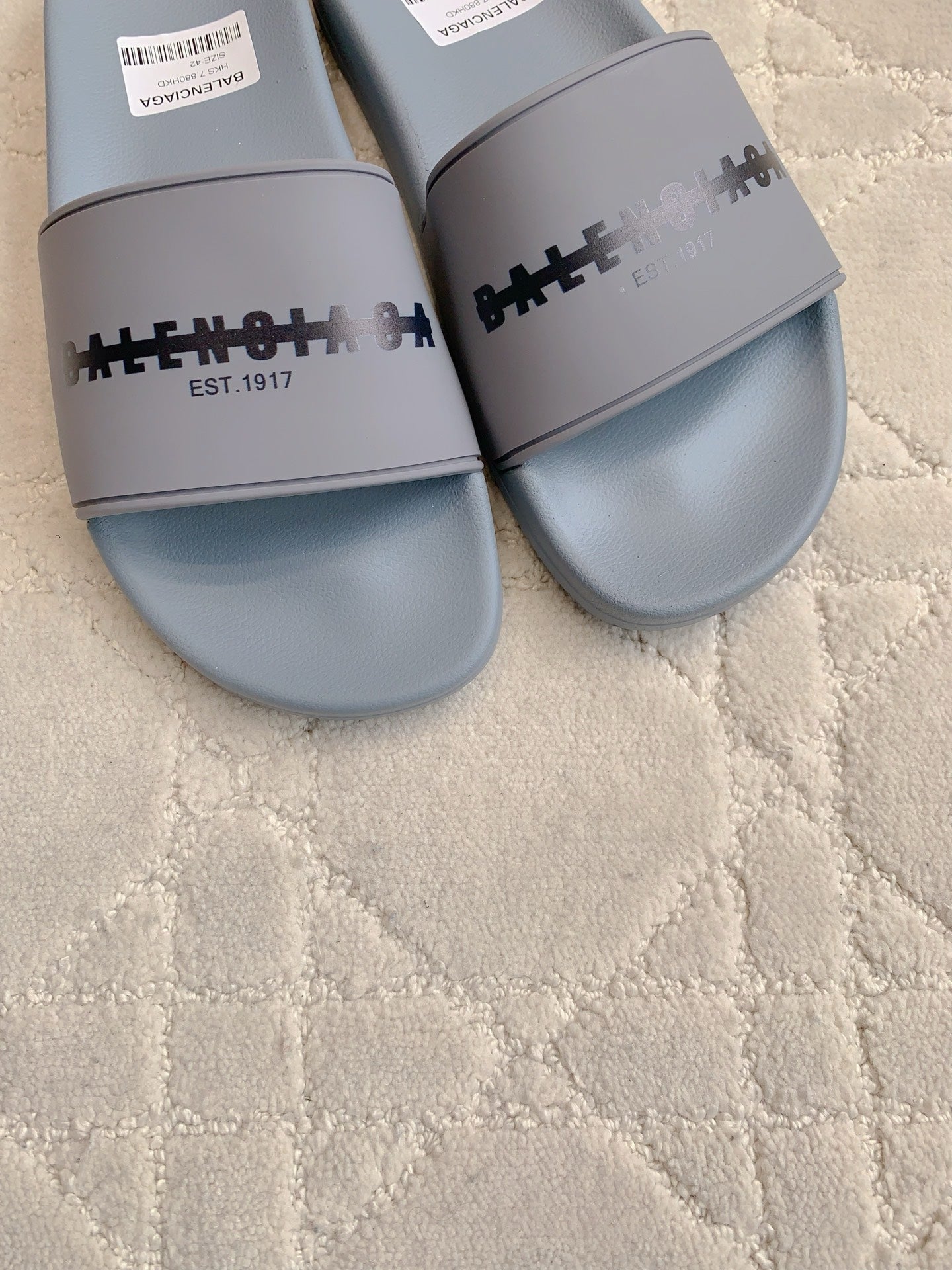 Light blue slide sandals close-up of logo strap and footbed
