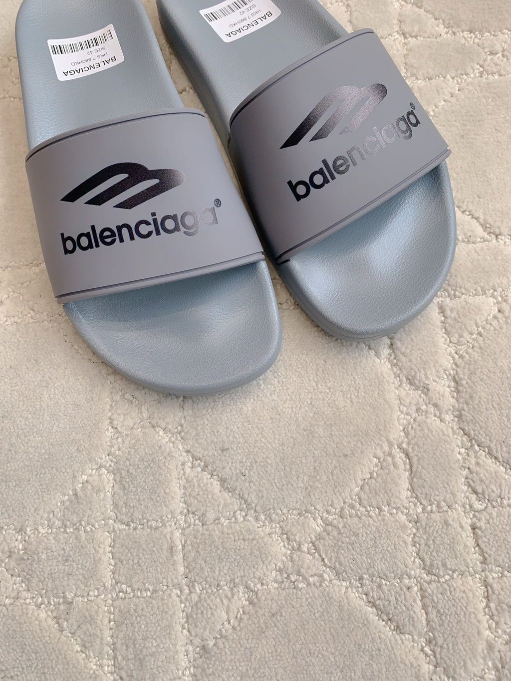 Balenciaga slide sandals, light gray, close-up of front logo strap