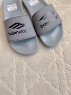 Balenciaga slide sandals, light gray, close-up of front logo strap