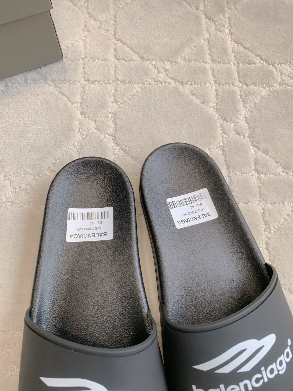 Balenciaga black slide sandals close-up, textured footbed and logo strap