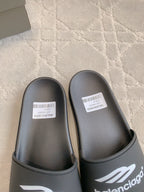 Balenciaga black slide sandals close-up, textured footbed and logo strap