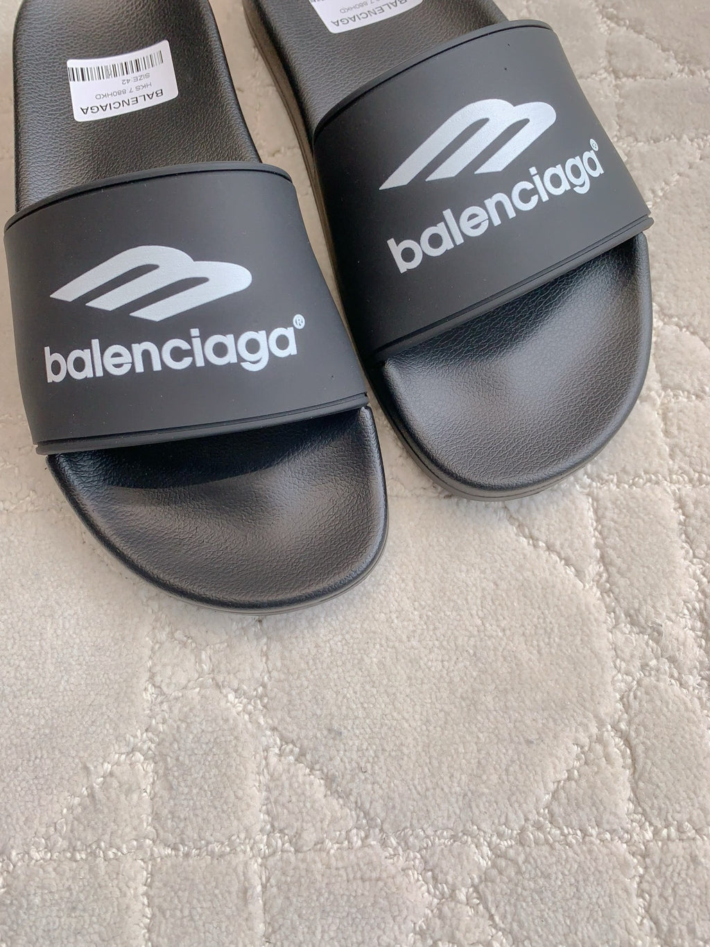 Balenciaga black slide sandals close-up, wide strap with white logo