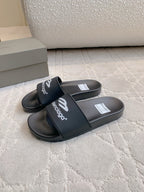 Balenciaga black slide sandals with cross strap and printed logo on footbed