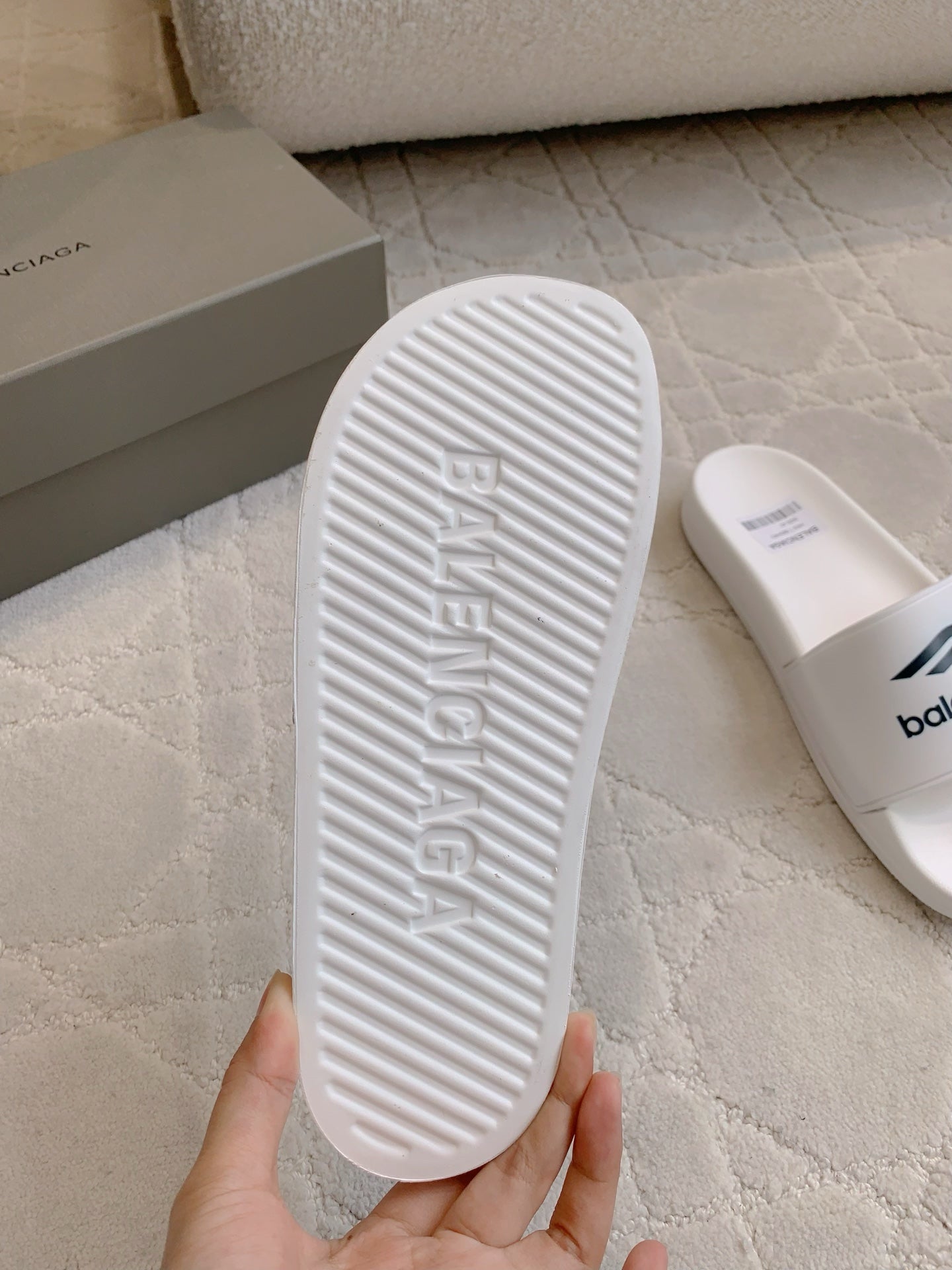 White Balenciaga slide sandal outsole with textured ridges and “balenciaga” imprint