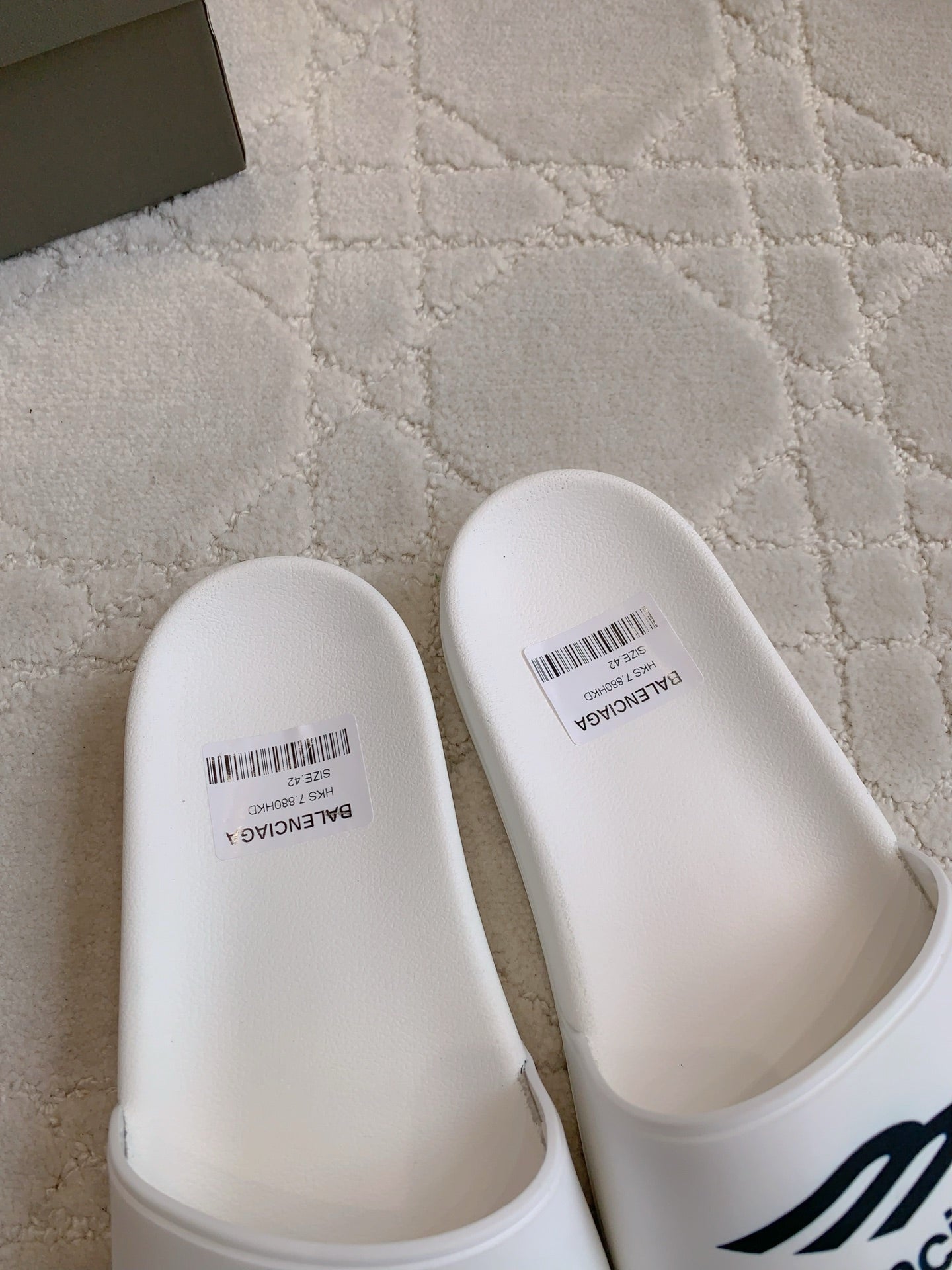 White Balenciaga slide sandals with smooth toe caps and barcode label details