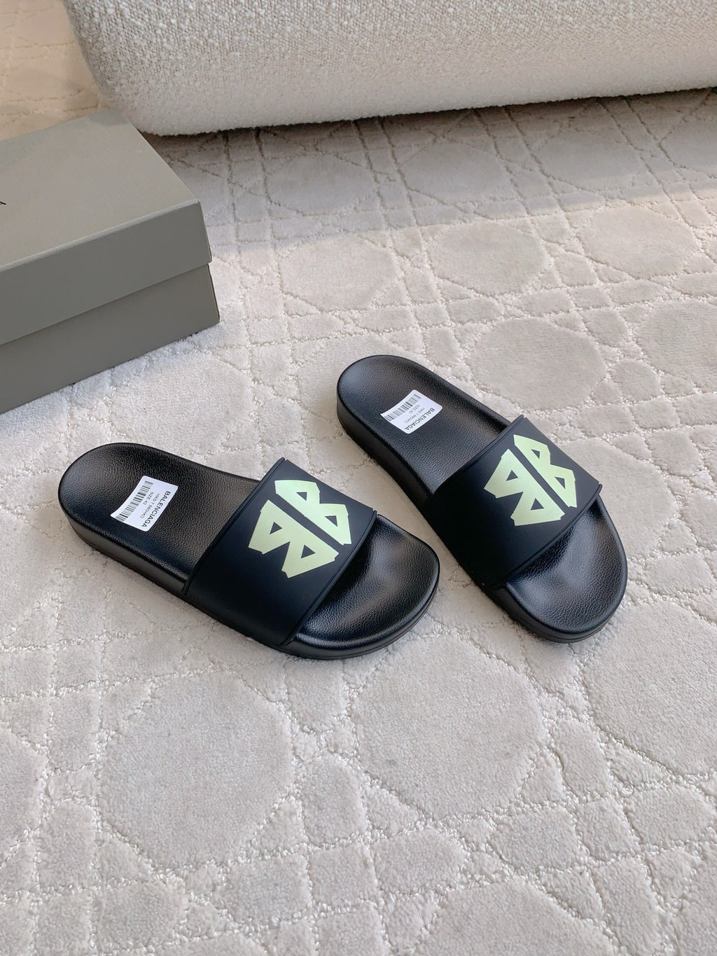 Balenciaga black slide sandals with green logo patches, side view