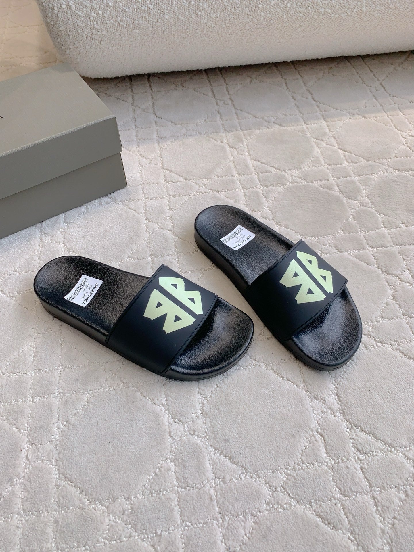 Balenciaga black slide sandals with green logo patches, side view