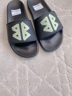 Balenciaga black slide sandals with green logo on front straps