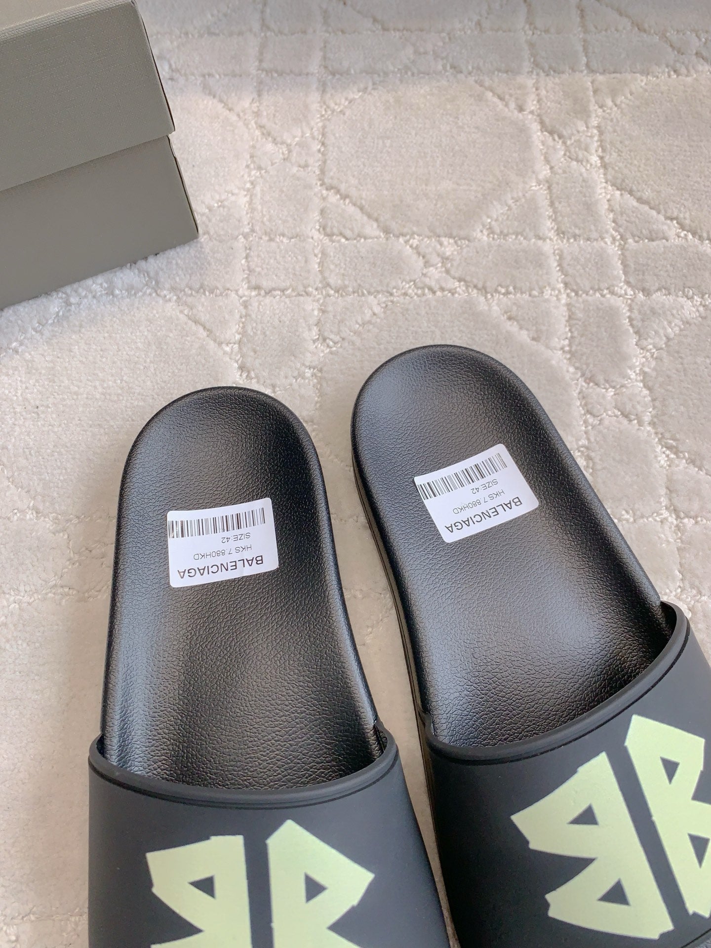 Balenciaga black slide sandals close-up, green logo on front strap