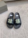 Balenciaga black slide sandals with green logo strap, cushioned footbed