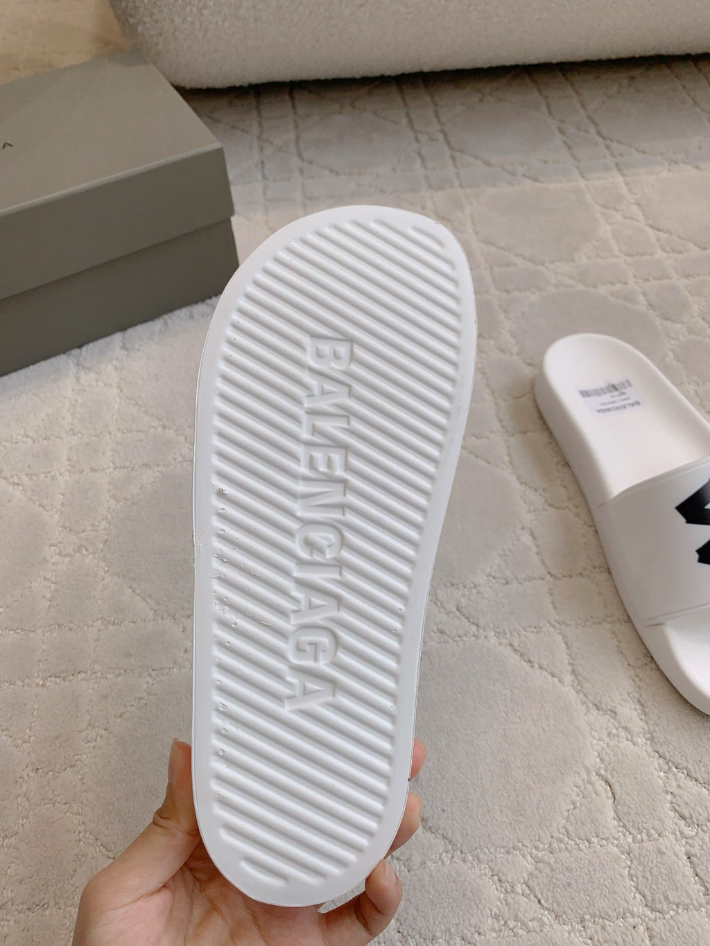 White Balenciaga slide sandal outsole with textured tread and logo embossing.
