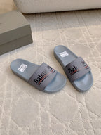 Balenciaga slide sandals pair, light blue-gray with logo strap across the top