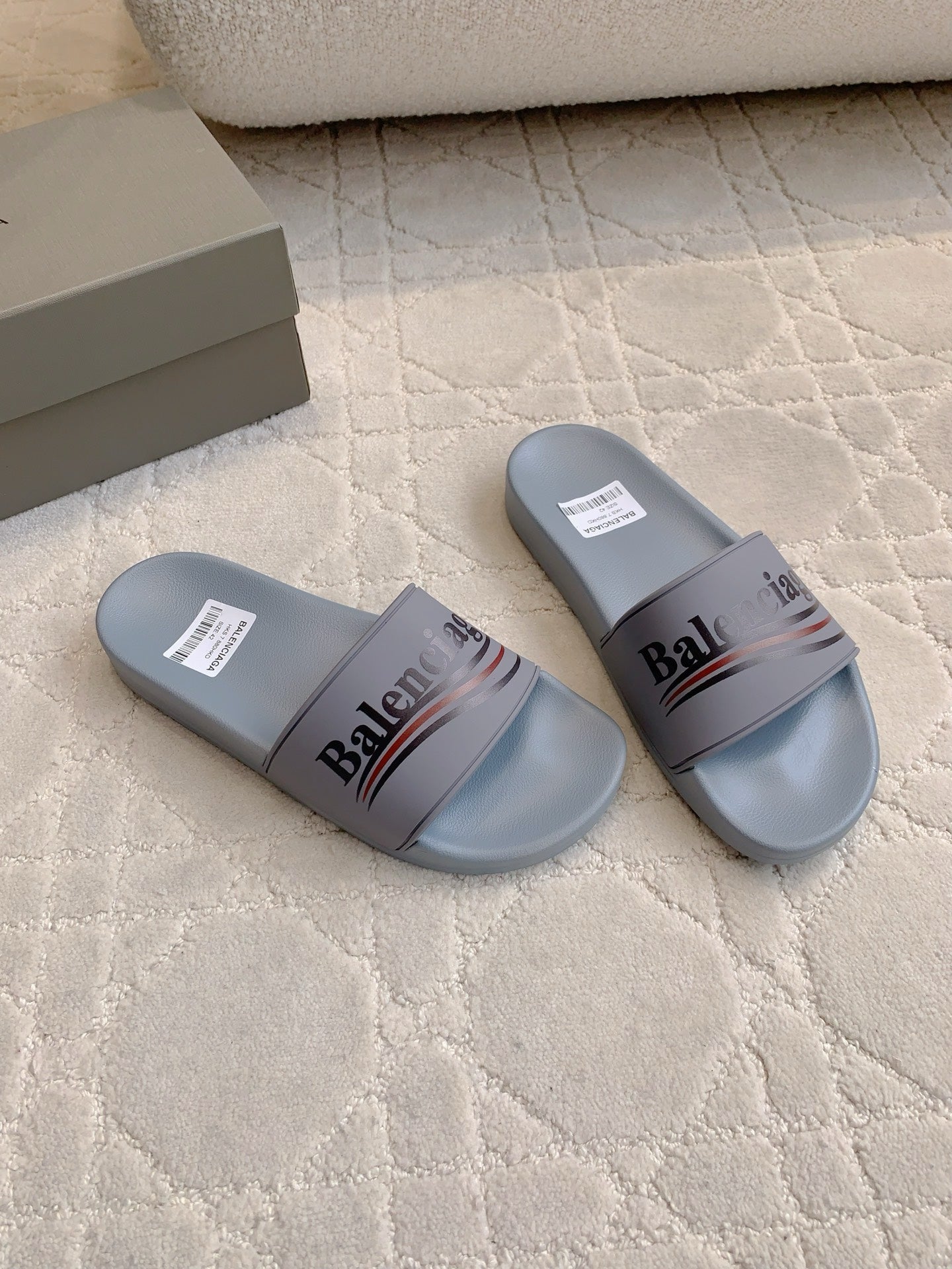Balenciaga slide sandals pair, light blue-gray with logo strap across the top