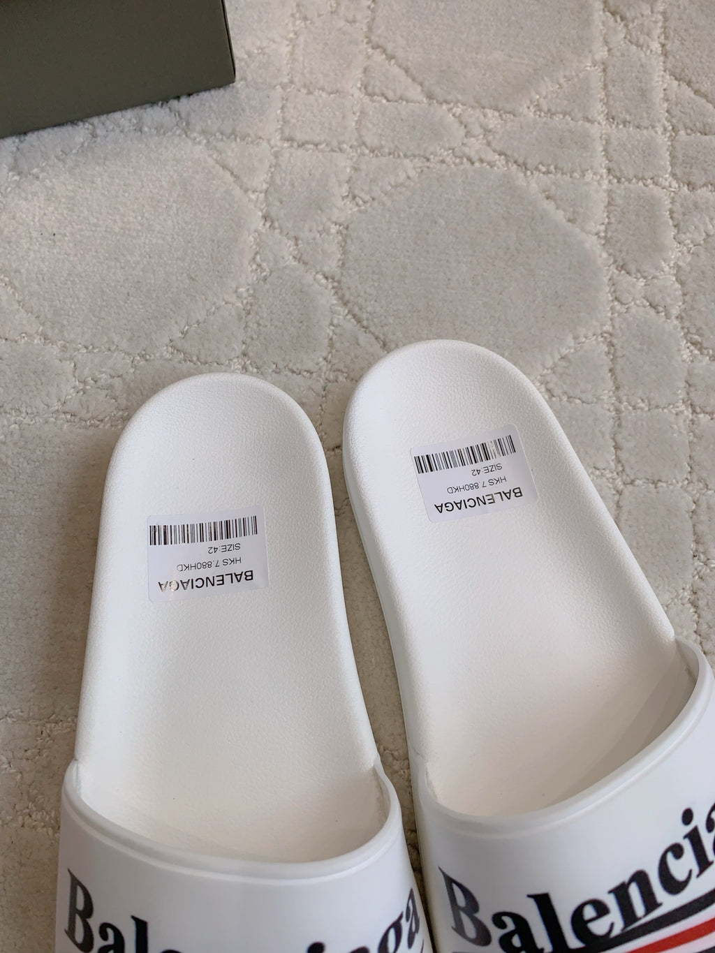 White slide sandals with Balenciaga logo on front strap
