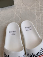White slide sandals with Balenciaga logo on front strap