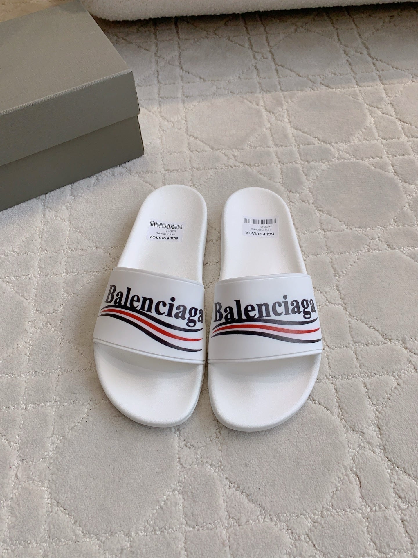 White slide sandals with Balenciaga logo on two-strap upper