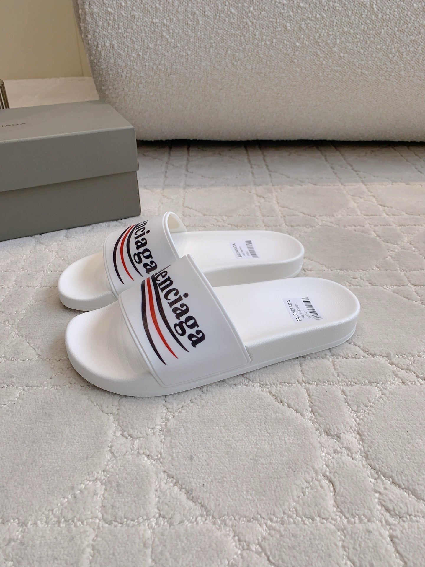 White slide sandals with Balenciaga logo strap and printed insole