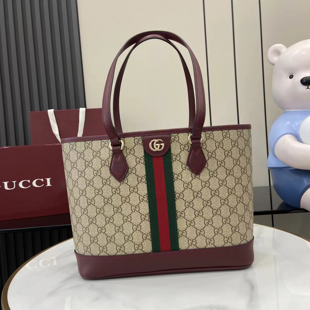 Gucci tote bag in GG canvas with burgundy trim, double handles, and green-red stripe