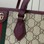 Gucci bag close-up: GG canvas with burgundy leather strap and trim
