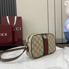 Gucci crossbody bag with beige GG canvas, stripe detail, and adjustable leather strap