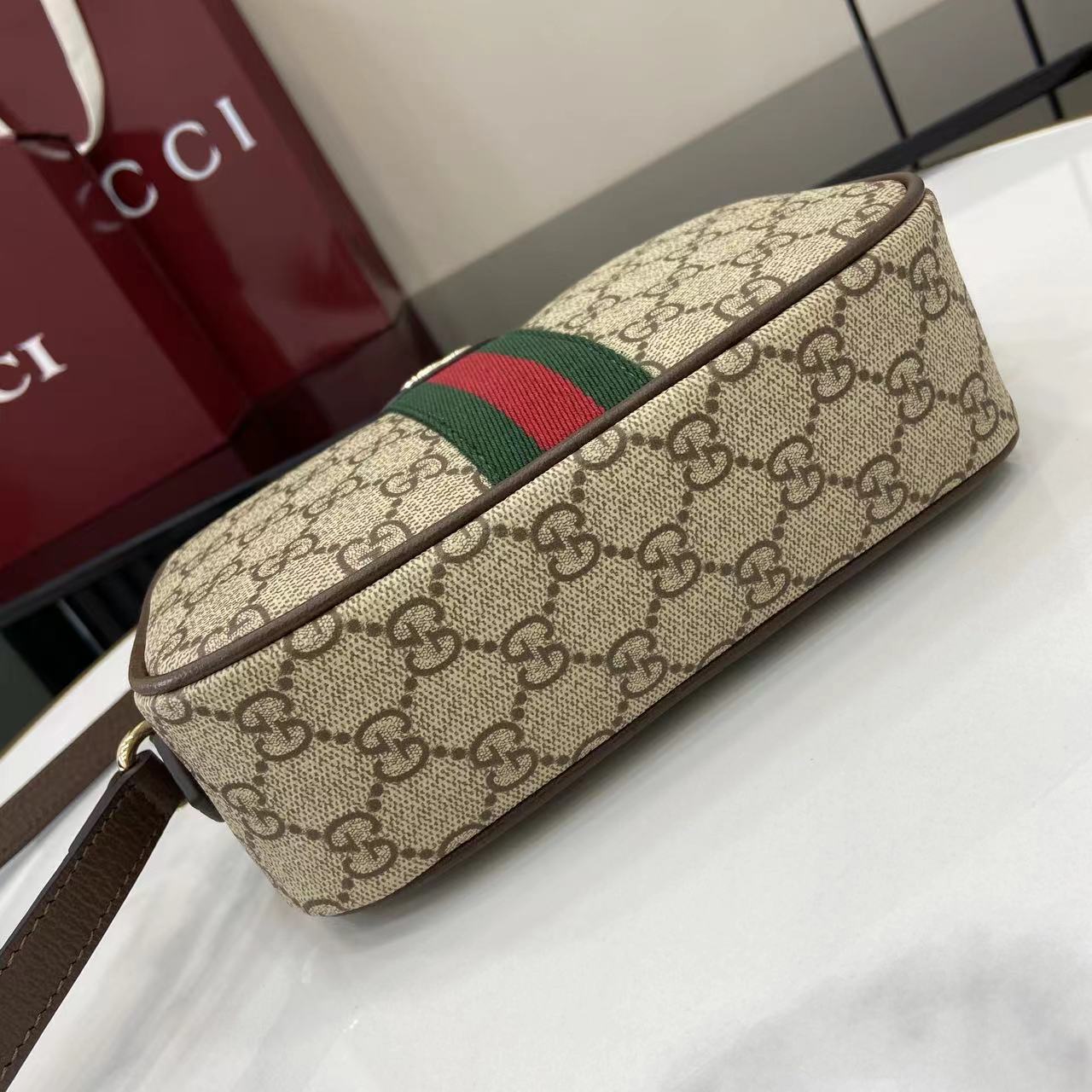 Gucci crossbody bag side view with beige GG canvas and green red web stripe