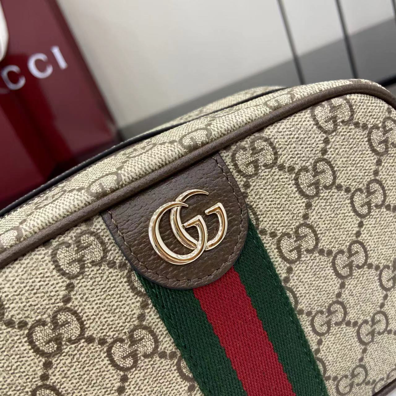 Gucci crossbody bag front logo patch with gold-toned emblem on brown leather