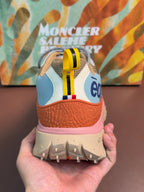 Heel view of light blue and orange sneakers with pink midsole and tread
