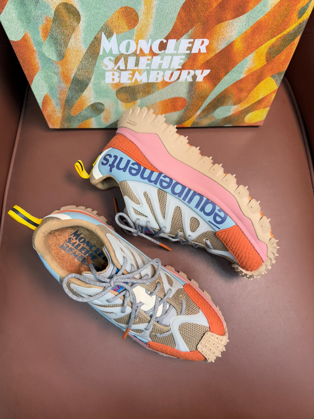 Blue and orange low-top sneakers with pink soles and lace-up front