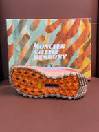 Shoe outsole with orange traction studs and rugged gray rubber sole