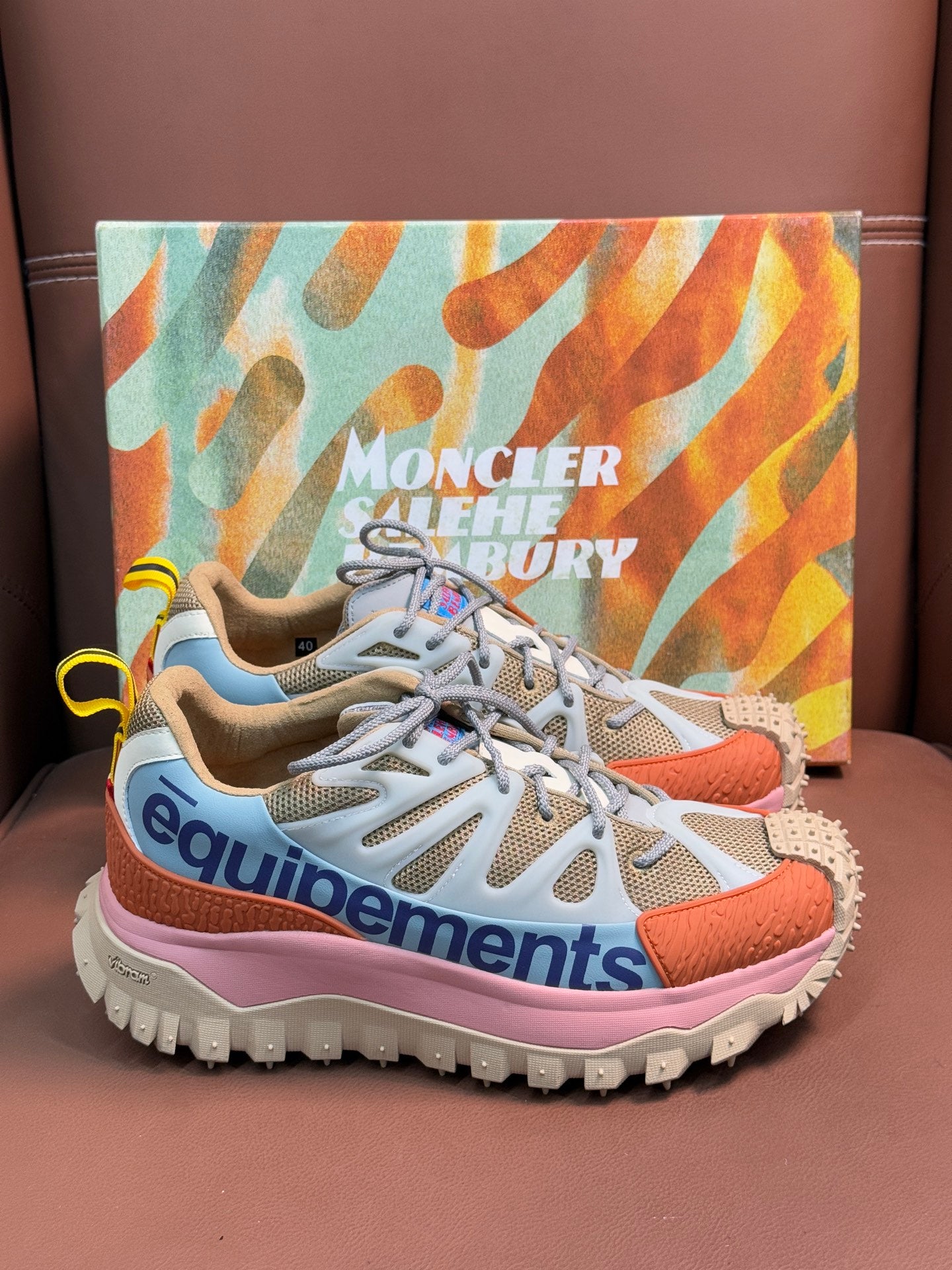 Gray and orange lace-up sneakers with pink midsole and studded tread