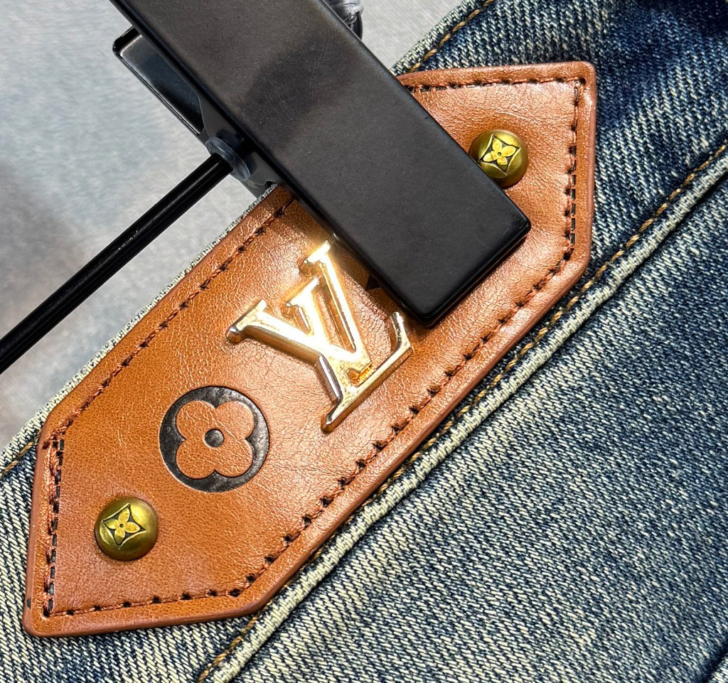 Leather coin holder detail with gold Louis Vuitton monogram on denim jeans