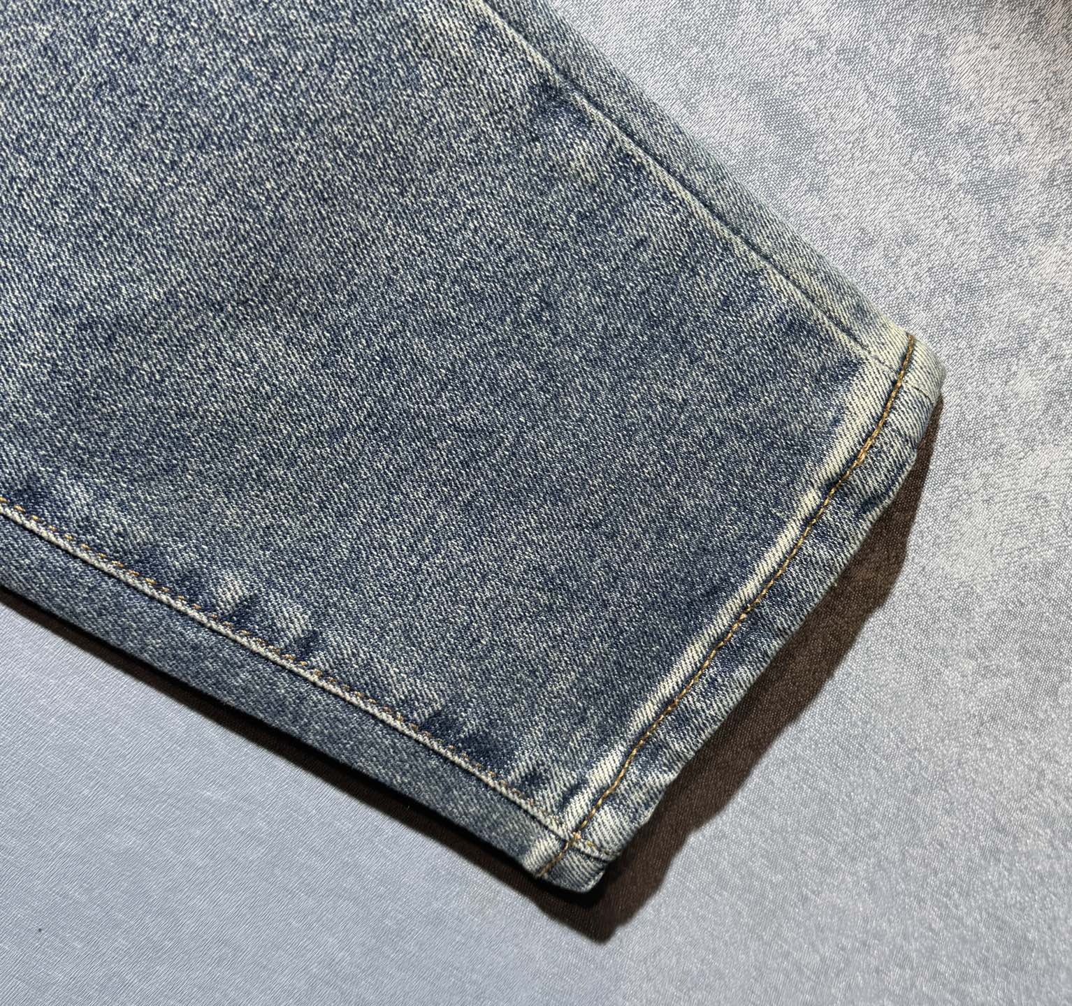 Hem of light wash denim pants with straight cuff stitching