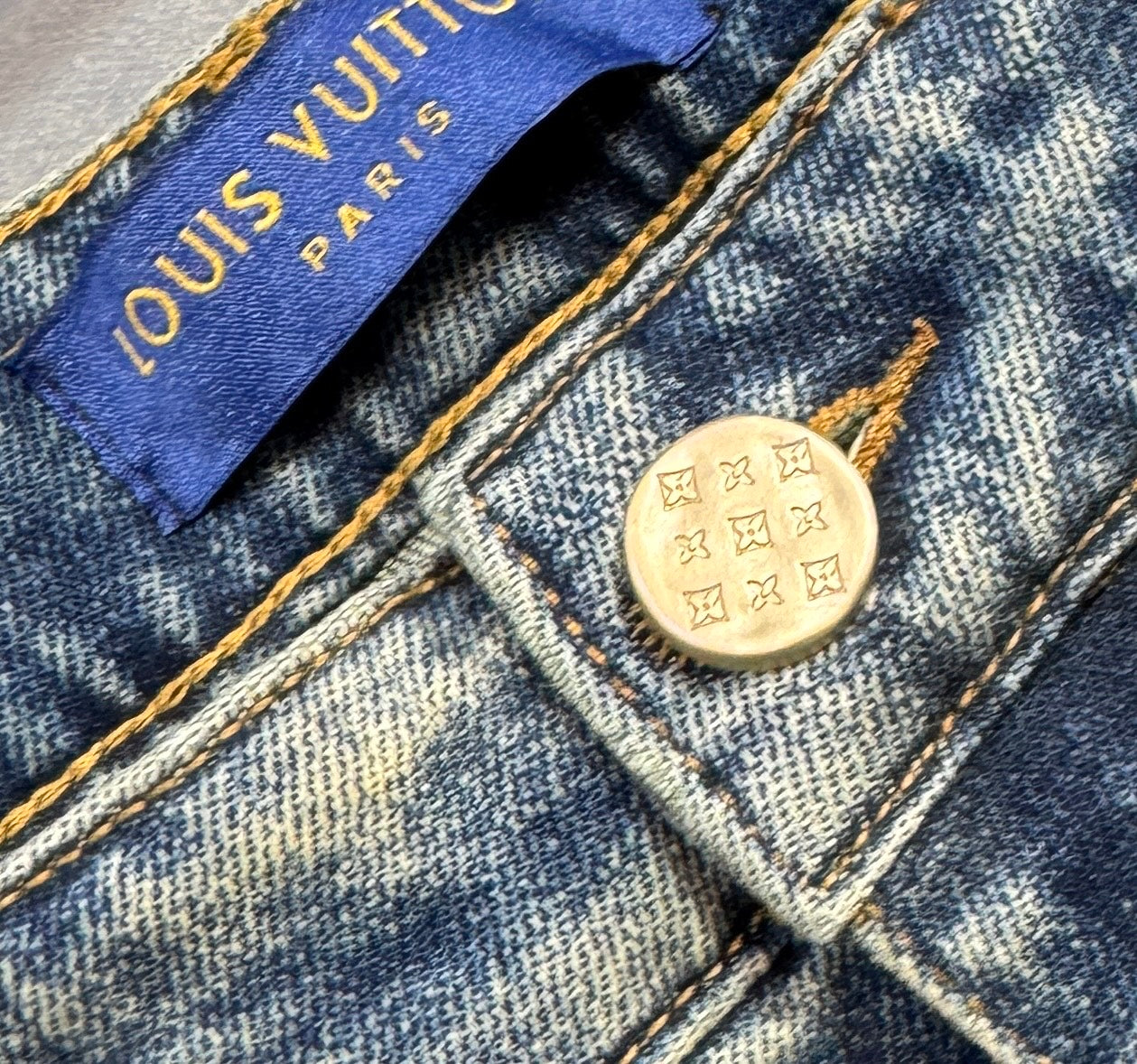 Denim jeans interior tag and round gold-tone snap button