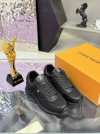 Black lace-up Louis Vuitton sneakers on box, pair view from above with laces visible.